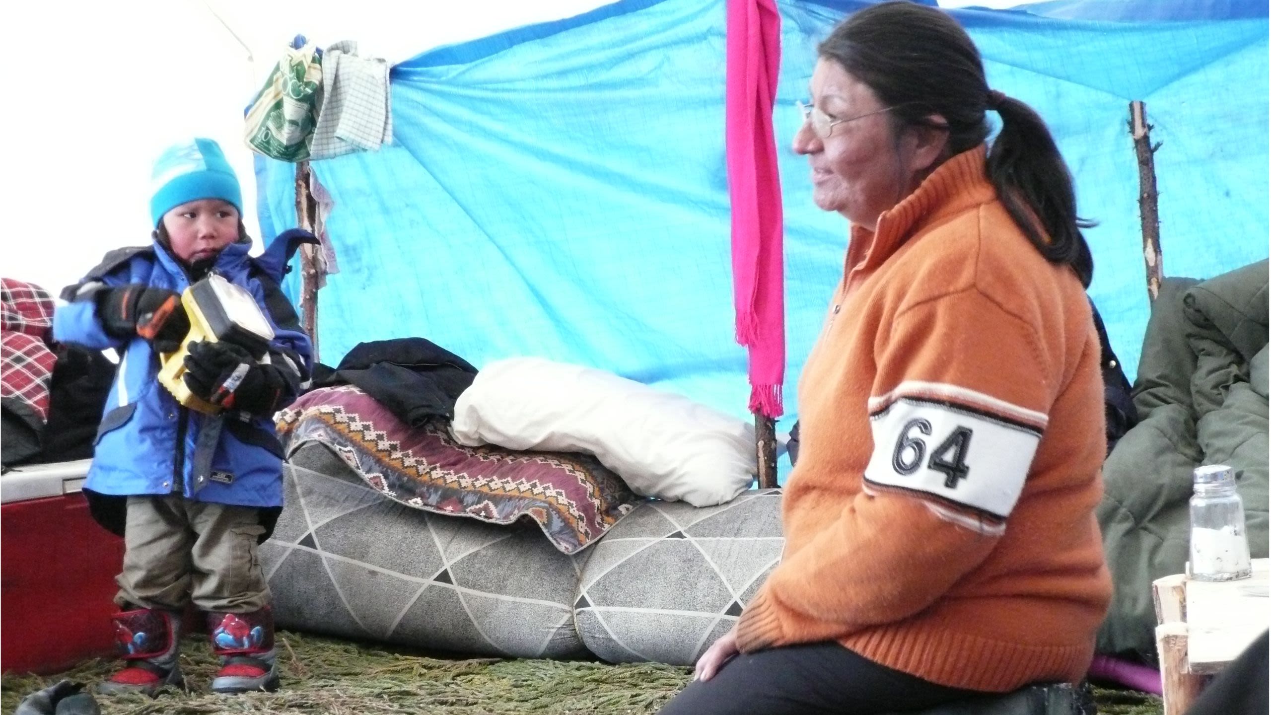 Innu child in tent with older woman